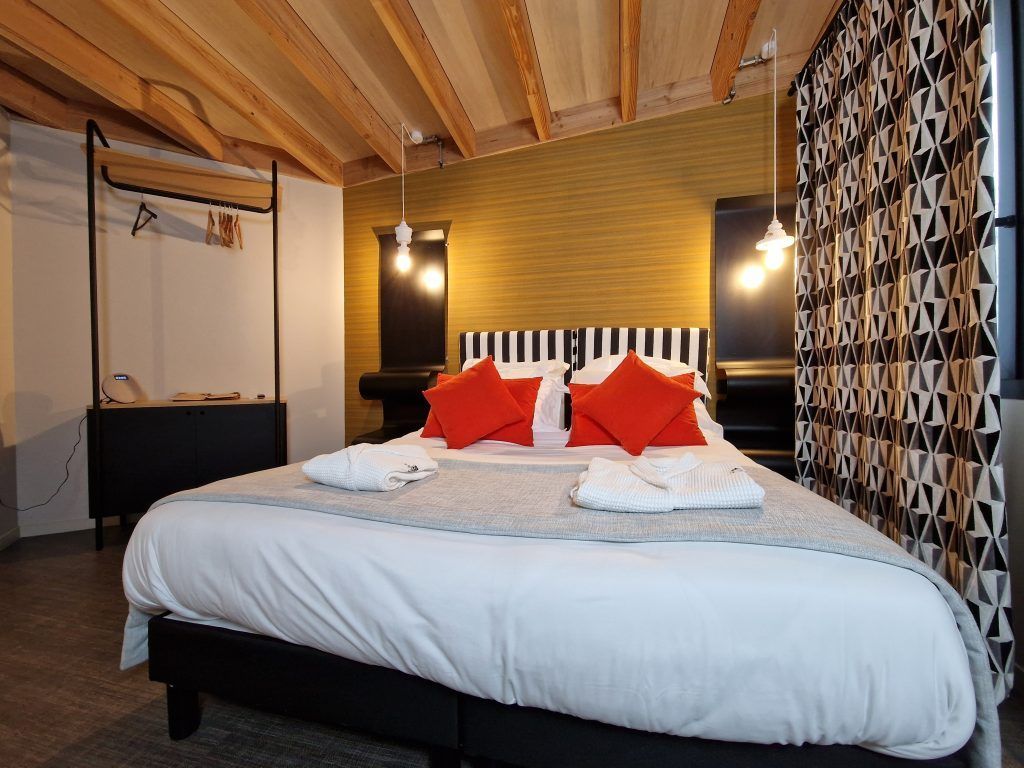 Chambre avec des coussins rouge sur le lit