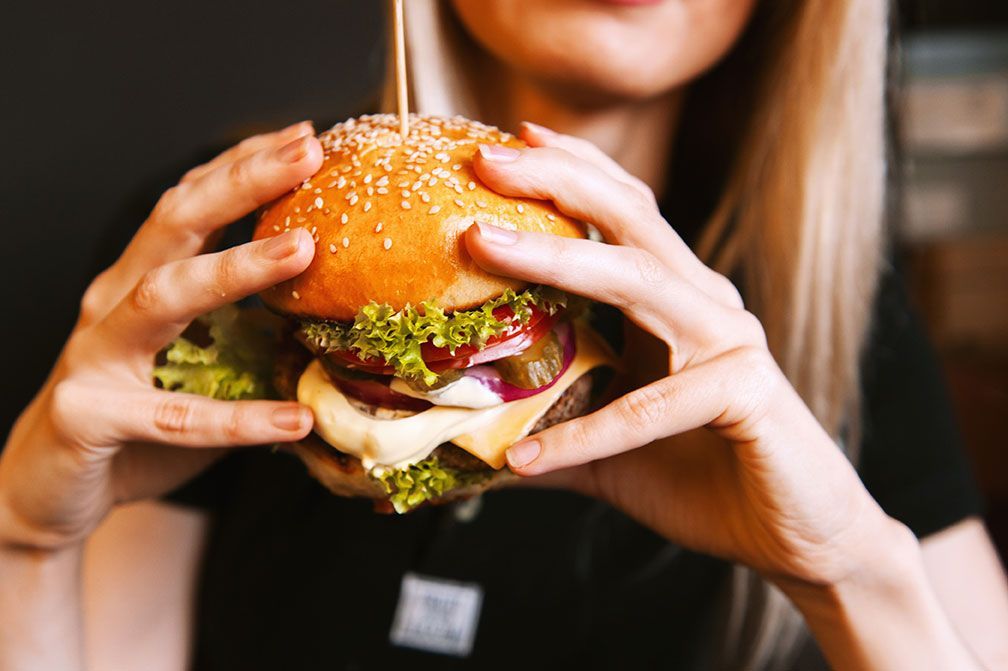 Femme qui mange un burger maison