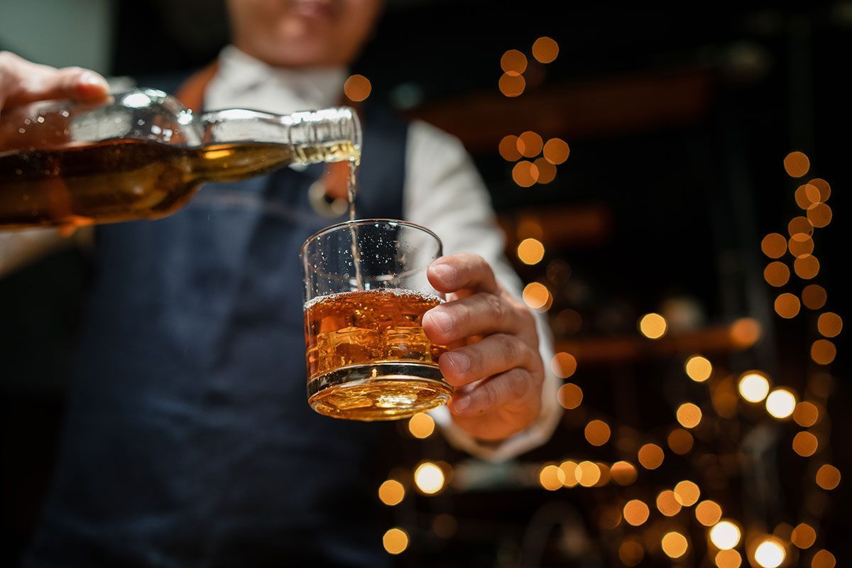 Homme qui sert du whisky