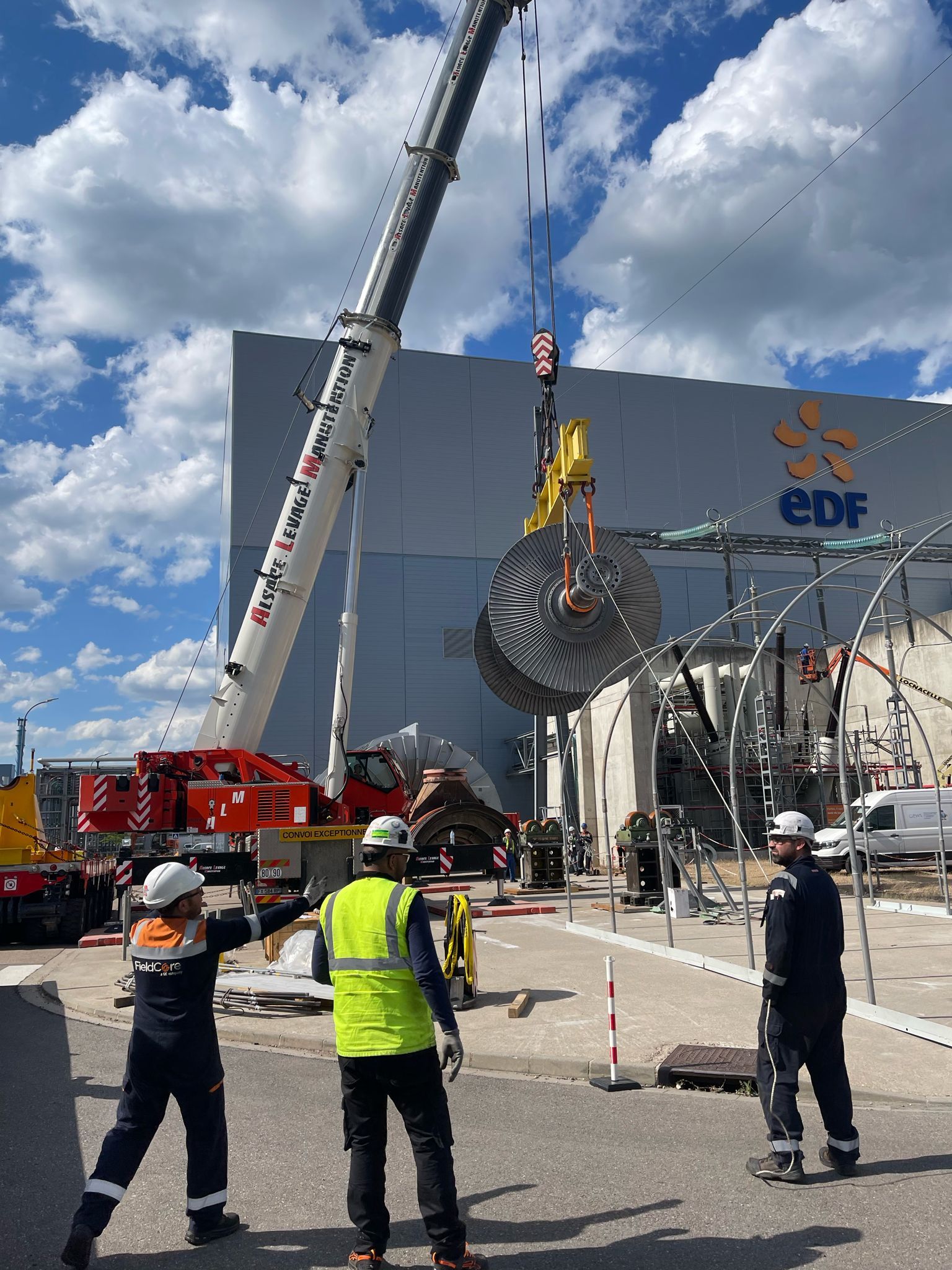 Camion grue soulevant un élément métallique spéhirque