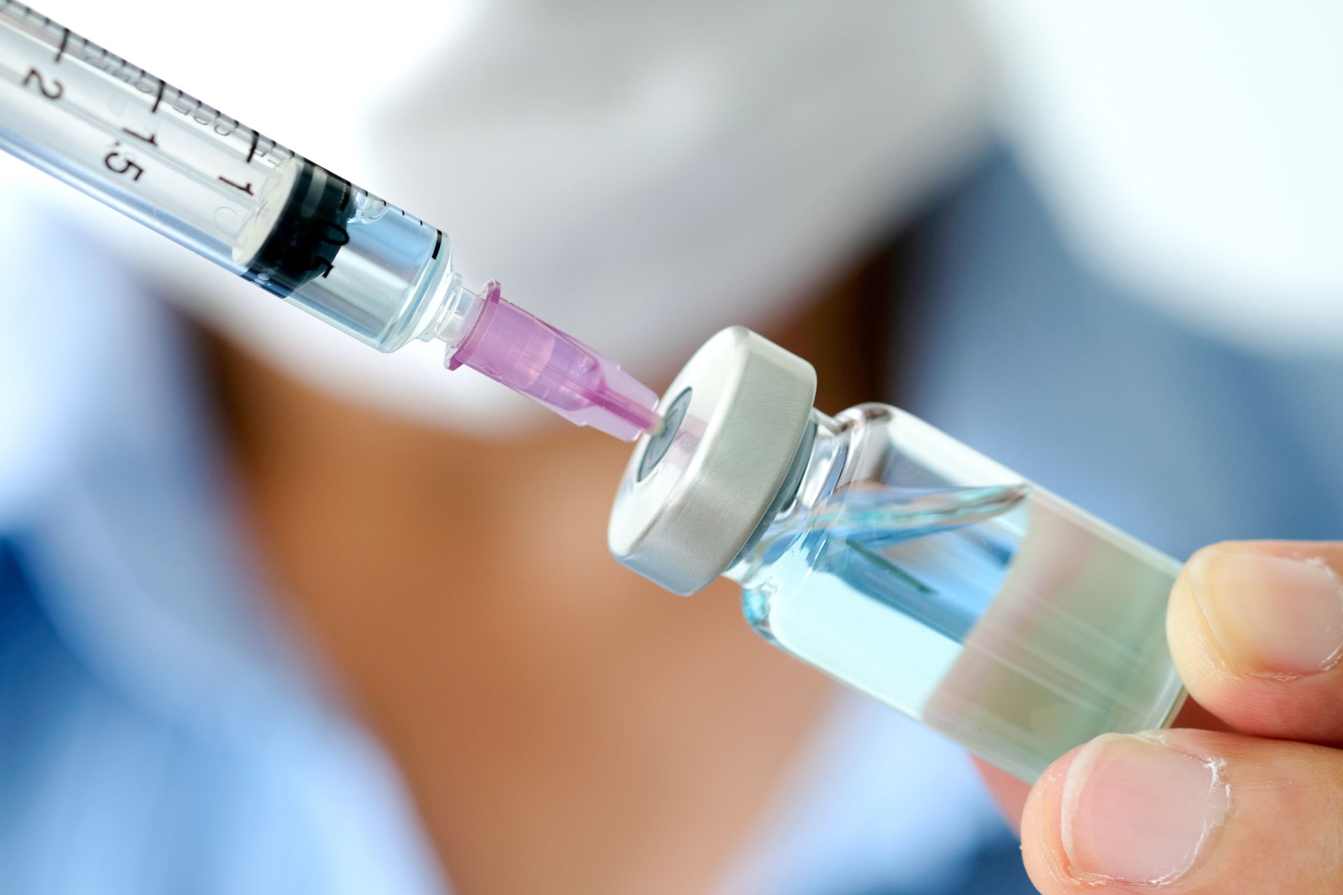 Seringue qui prélève un vaccin dans une fiole de produit