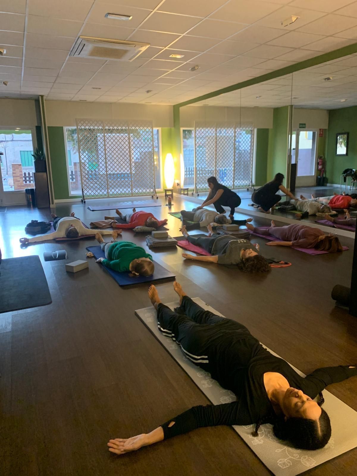 Mujer en una pelota de ejercicio estirando la espalda en un gimnasio.