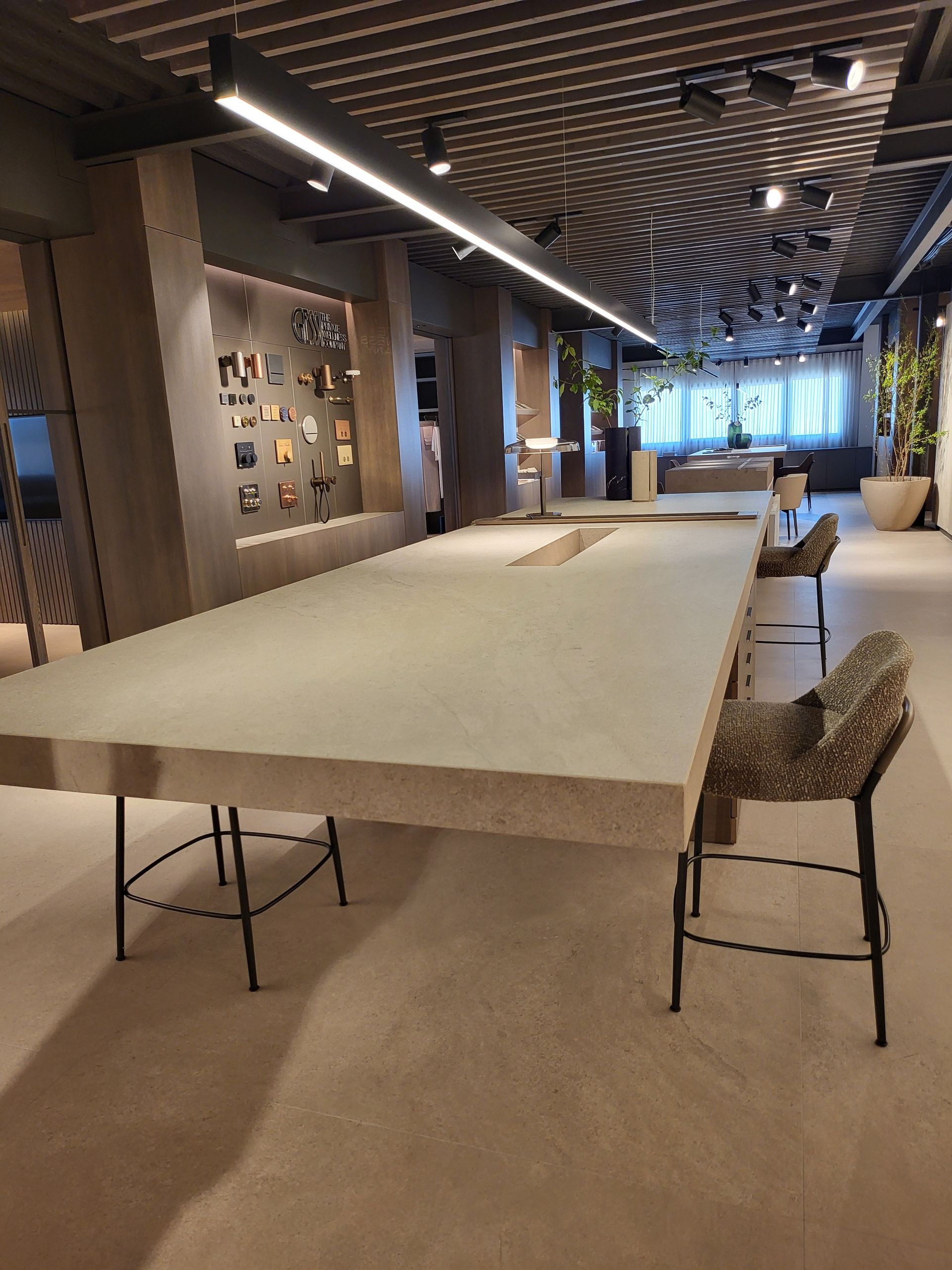 Mesa rectangular larga con dos sillas estampadas en un espacio de oficina moderno.