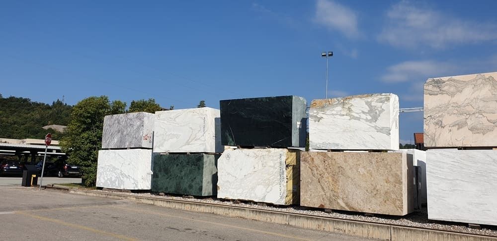 Pilas de bloques de piedra de distintos colores yacen afuera bajo un cielo azul.