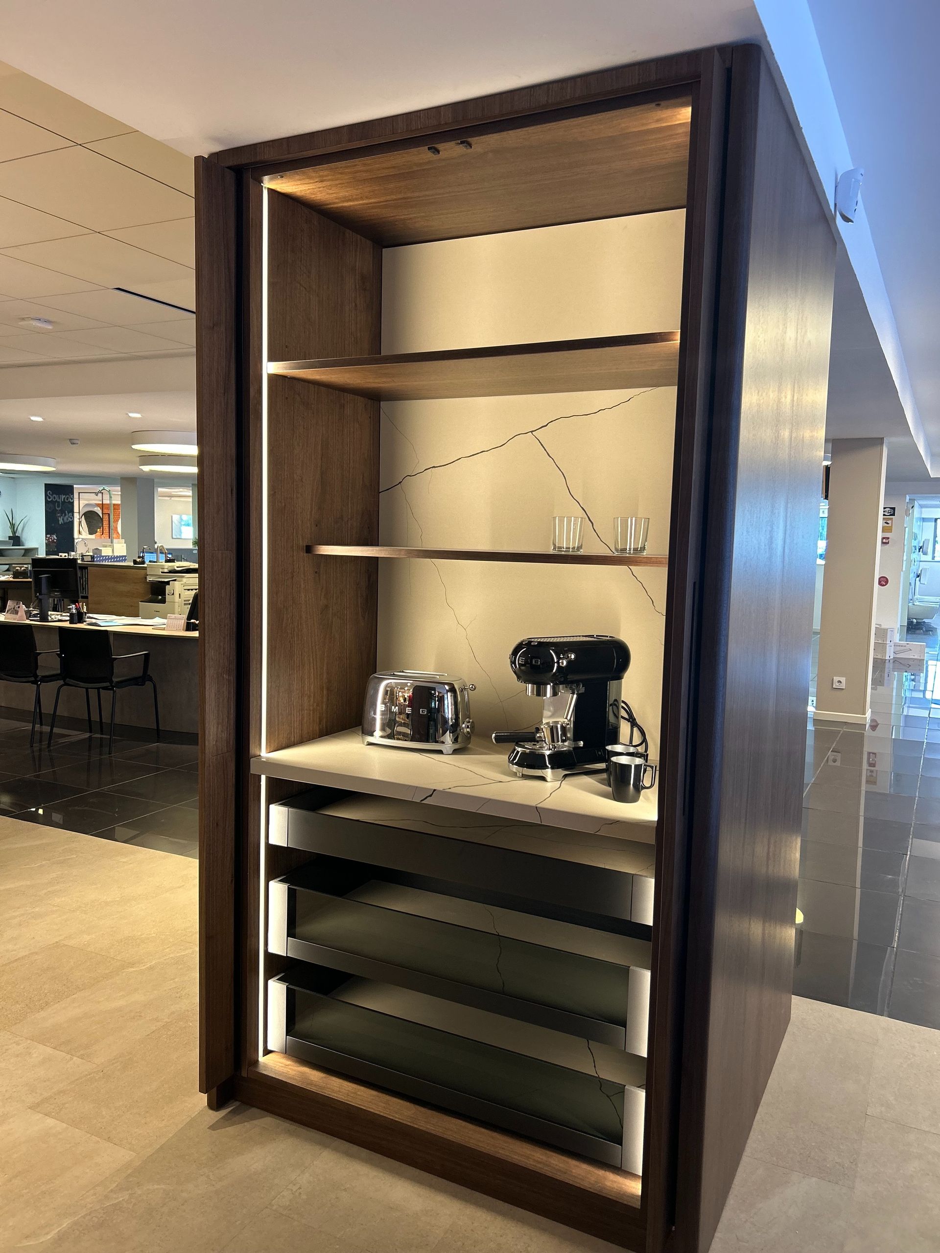 Estación de café de madera con tostadora, cafetera y estantes.