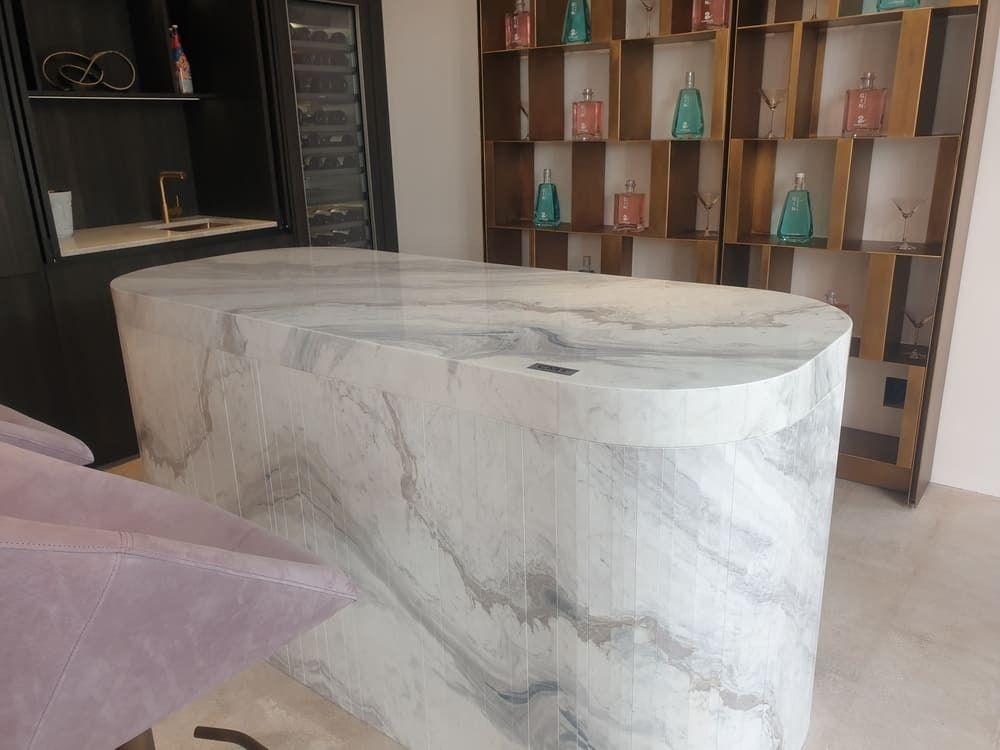 Encimera de mármol en una tienda, rodeada de estanterías con artículos expuestos.