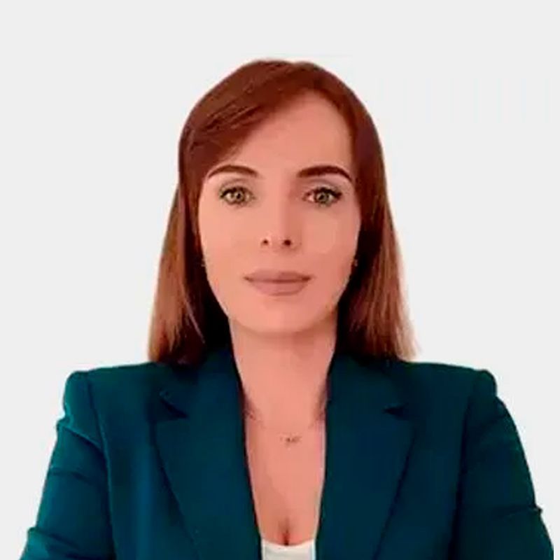 Hombre de ojos marrones, barba y sonriente; viste camisa azul claro y tirantes.