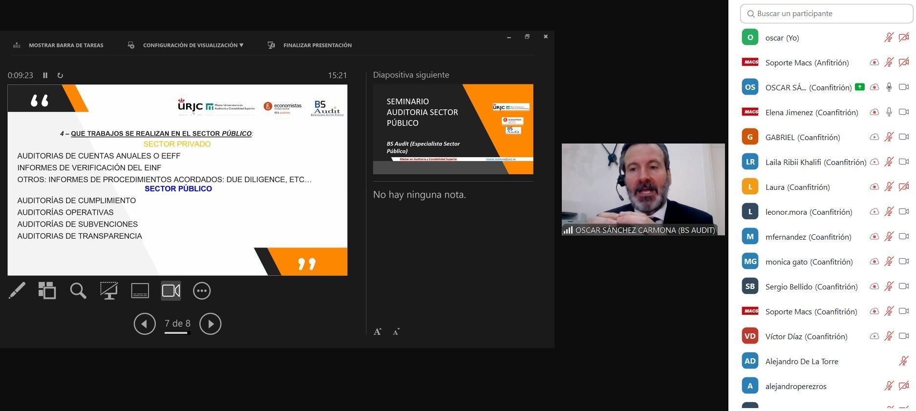 Un hombre con traje está dando una presentación por videoconferencia. Las diapositivas muestran texto con un tema naranja y negro.