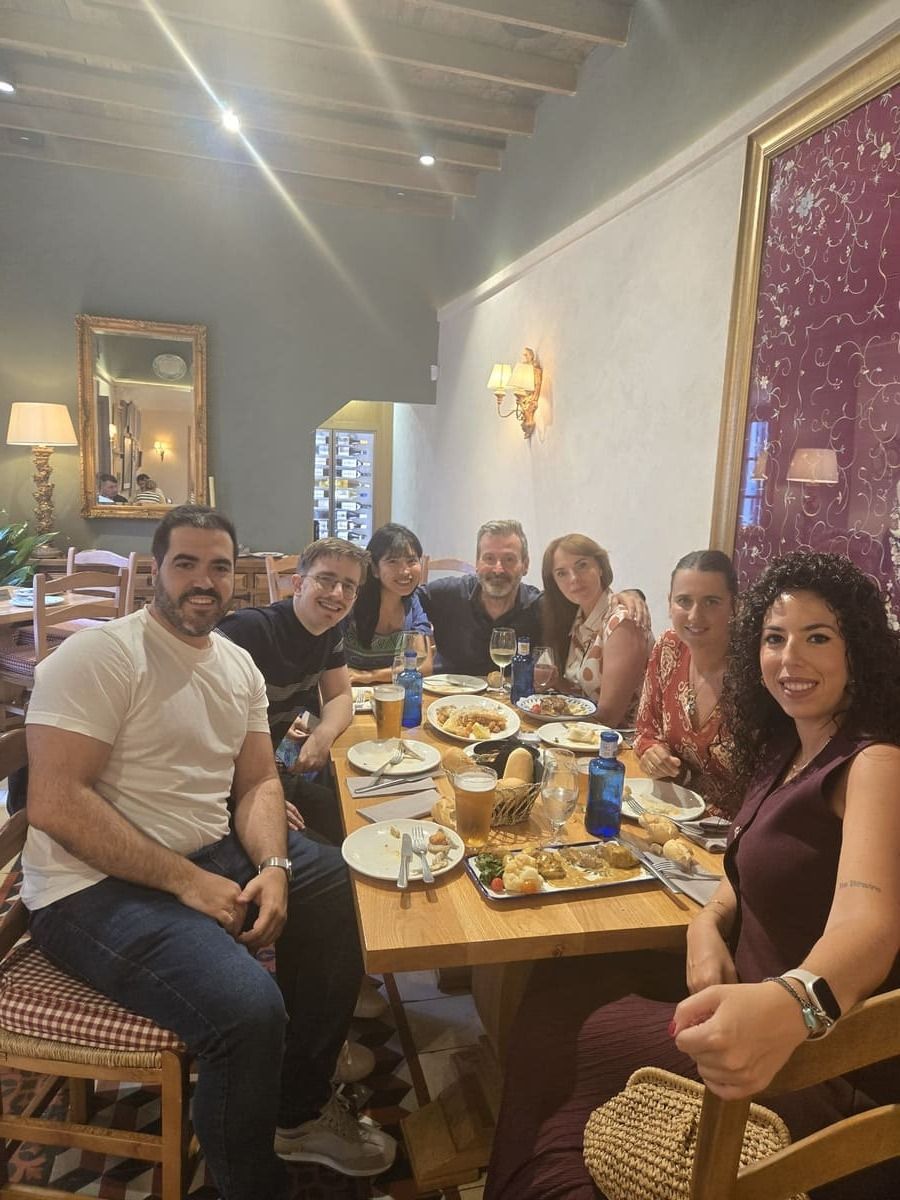 Un grupo de personas sentadas alrededor de una mesa, disfrutando de una comida en el interior.