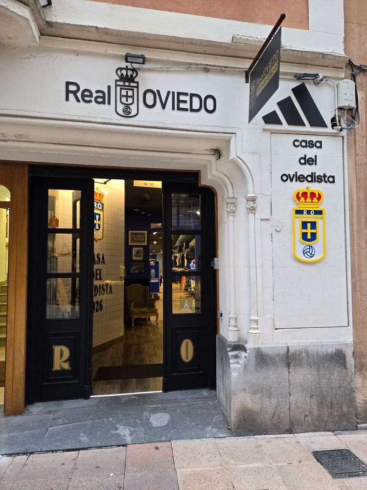 Entrada de la tienda del Real Oviedo con señalización y puertas abiertas.
