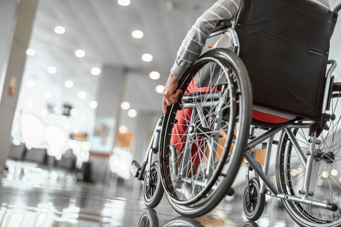 Una persona en silla de ruedas está sentada en un pasillo.