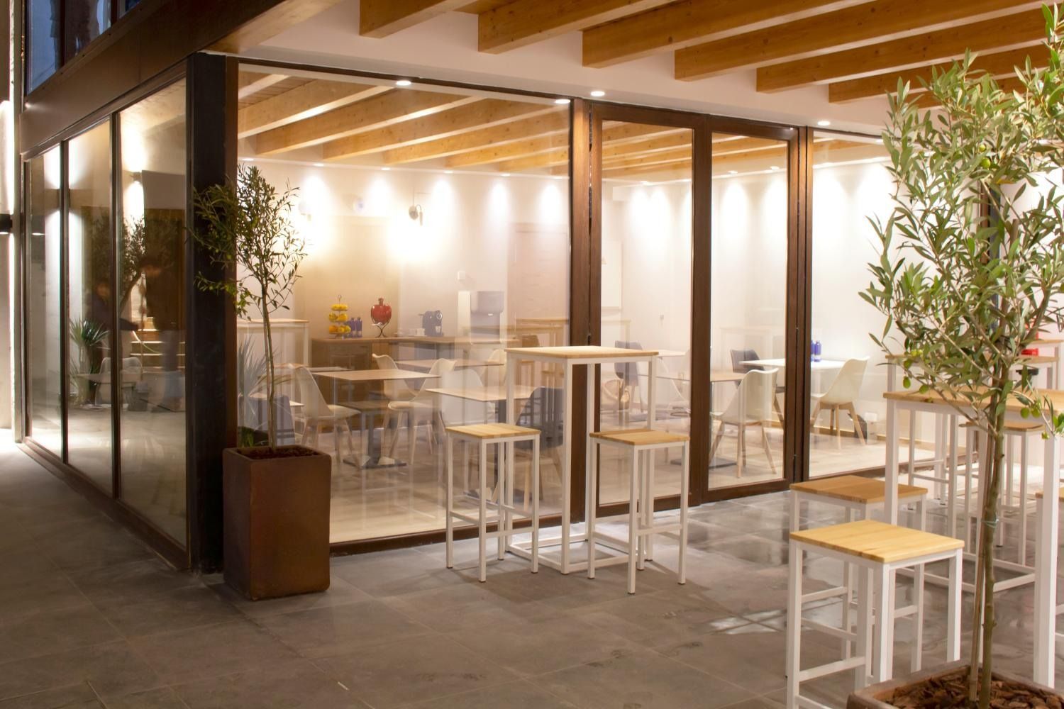 Un restaurante con mesas y sillas frente a un gran ventanal.