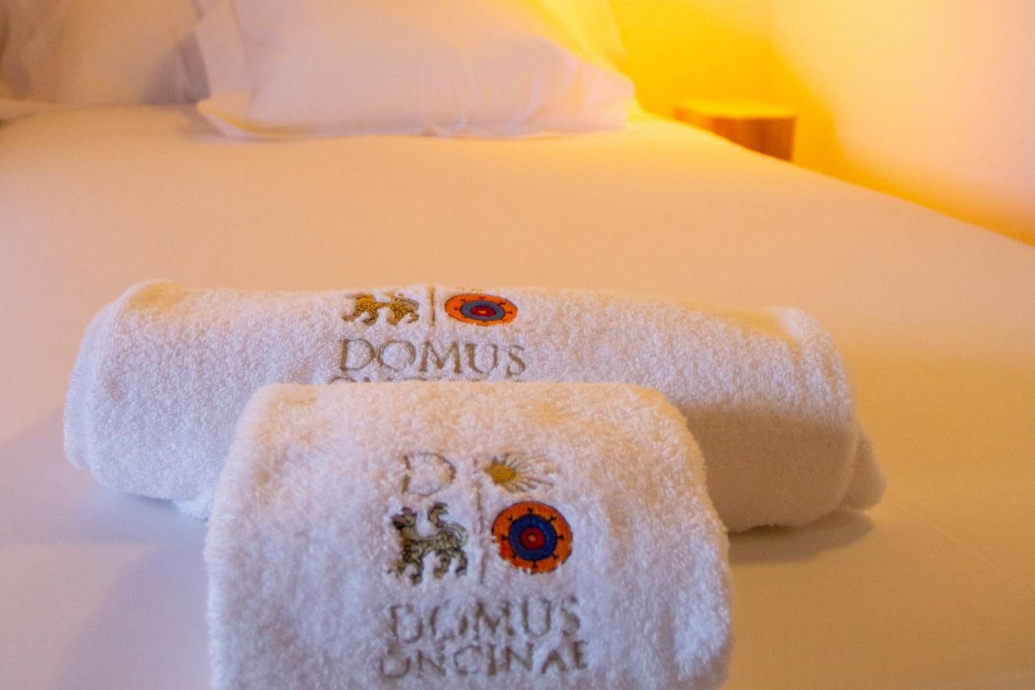 Dos toallas blancas están encima de una cama.