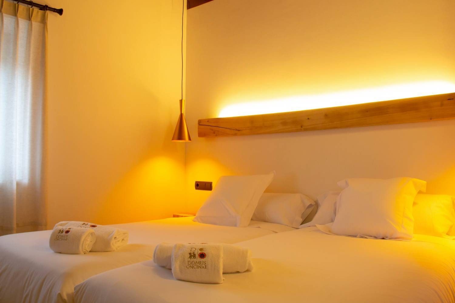 Una habitación de hotel con dos camas y un cabecero de madera.