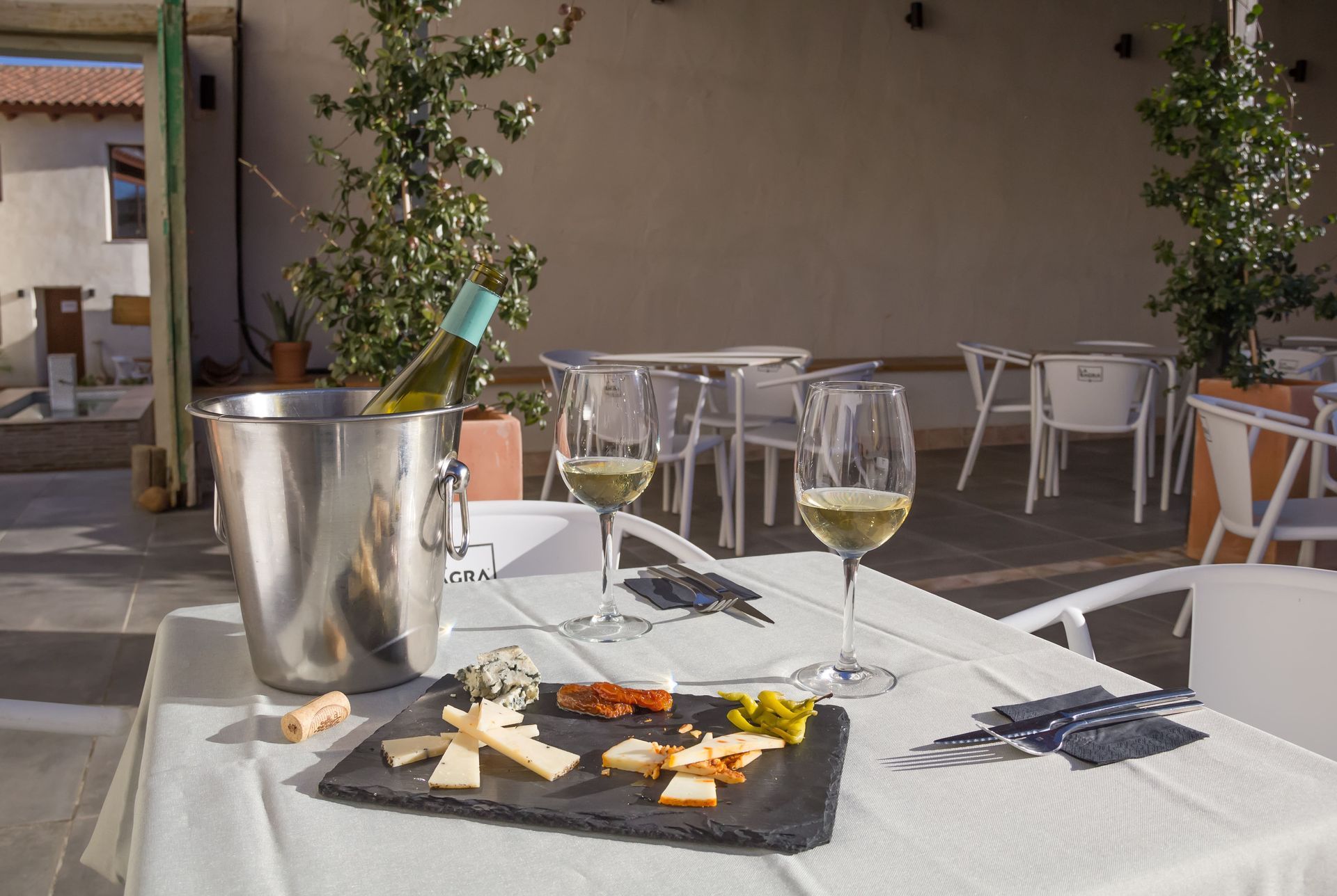 Una mesa con un cubo de champán y dos copas de vino encima.