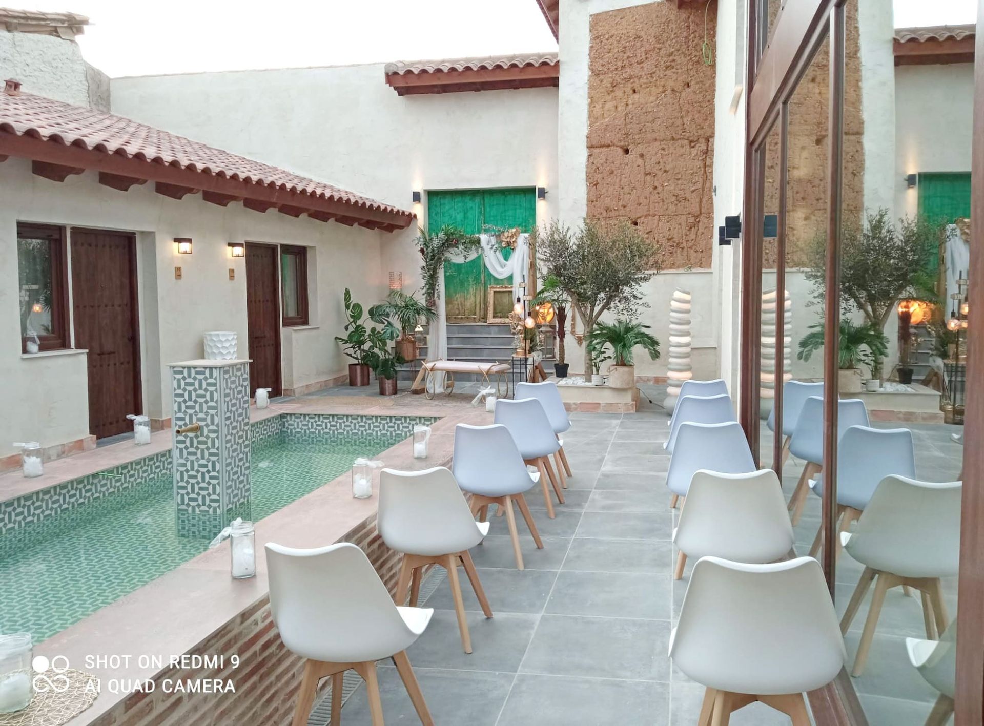 Una fila de sillas están sentadas frente a una piscina.