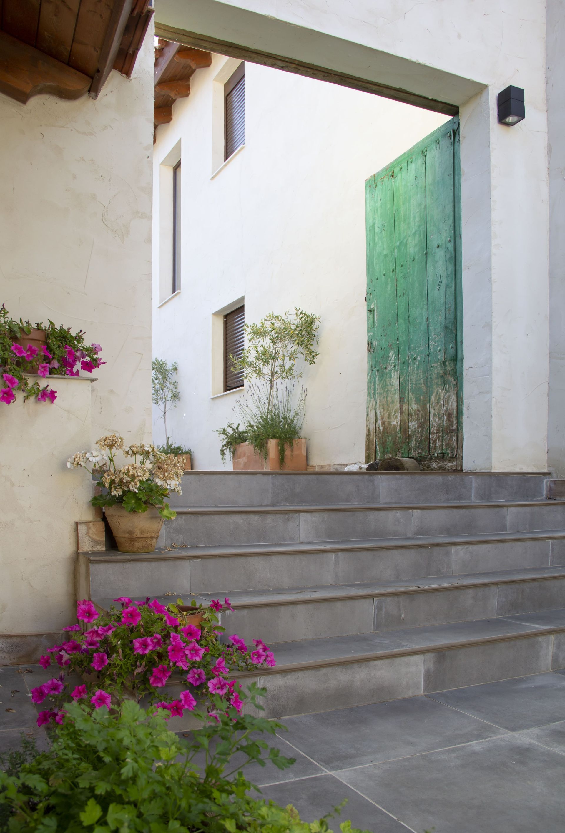 Un conjunto de escaleras que conducen a una casa con flores al costado.