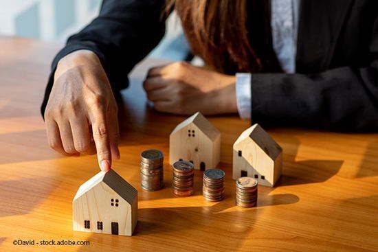 Stapel Kleingeld mit Miniaturhäusern