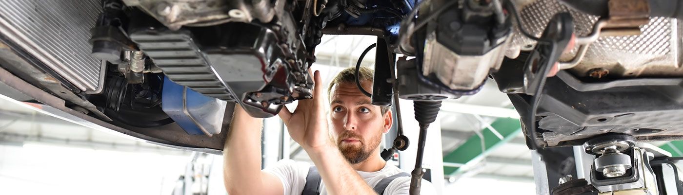 Ein Mann arbeitet an der Unterseite eines Autos.