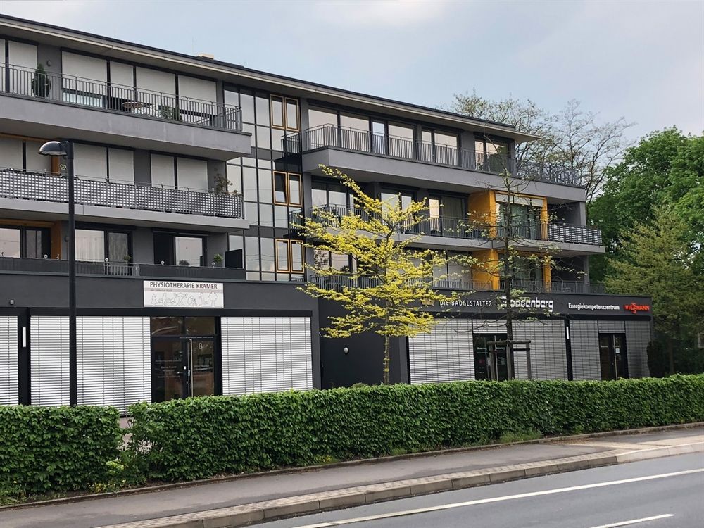 Ein Gebäude mit vielen Fenstern und einem Baum davor