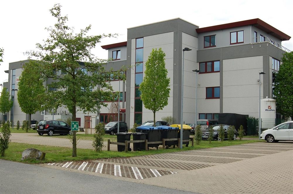 Ein weißes Auto steht vor einem großen Gebäude