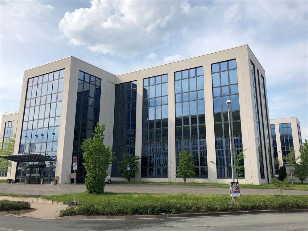 Ein großes Gebäude mit vielen Fenstern und Bäumen davor