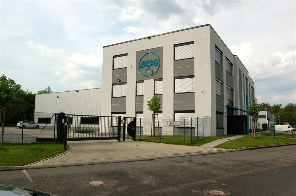 Ein großes weißes Gebäude mit einem Zaun und einem Schild mit der Aufschrift 