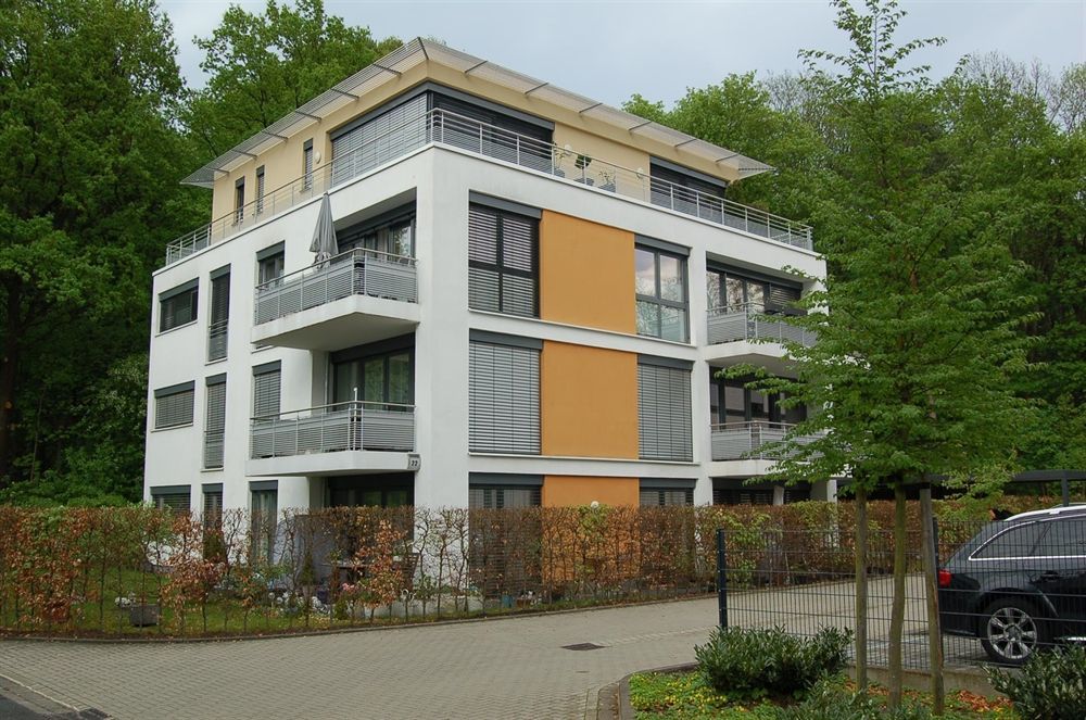 Ein großes Mehrfamilienhaus mit einem davor geparkten Auto