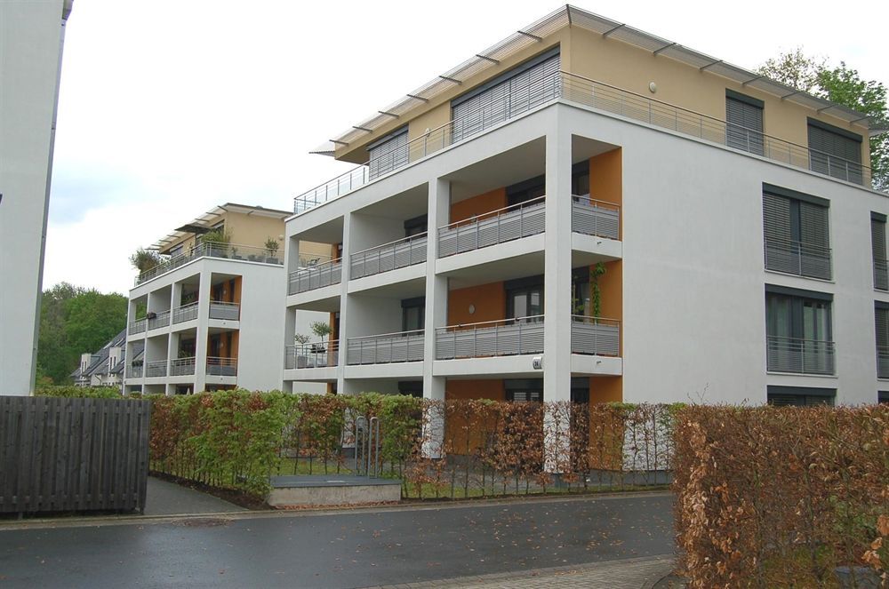 Ein Gebäude mit vielen Balkonen und einem Zaun darum