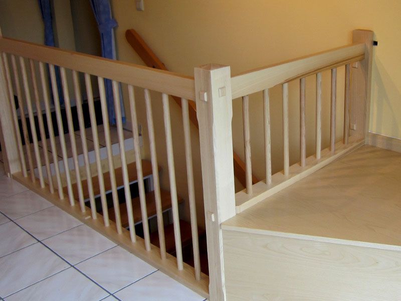 Eine Treppe mit Holzgeländer und Fliesenboden