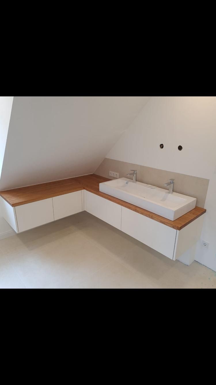Ein Badezimmer mit zwei Waschbecken und Schubladen darunter.