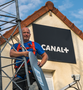 M. Hamelin posant devant son enseigne Canal+