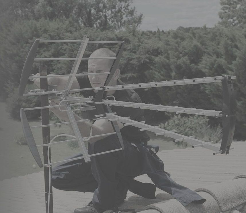 Techicien installant une antenne râteau