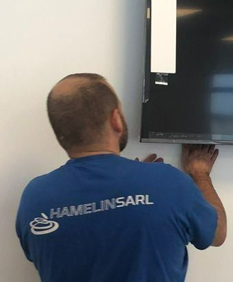 Technicien installant un écran plat au mur