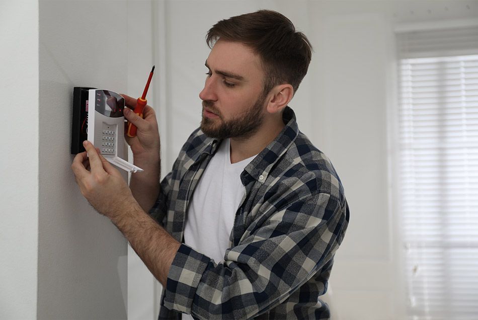 Technicien installant une alarme de sécurité