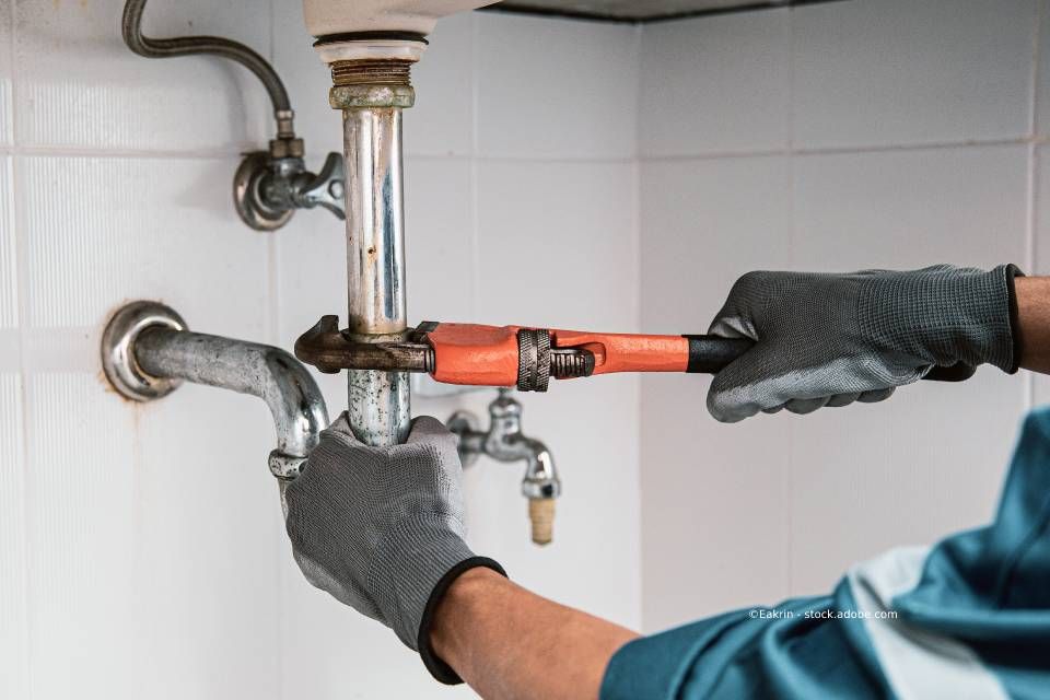 Klempner schraubt Rohr auf