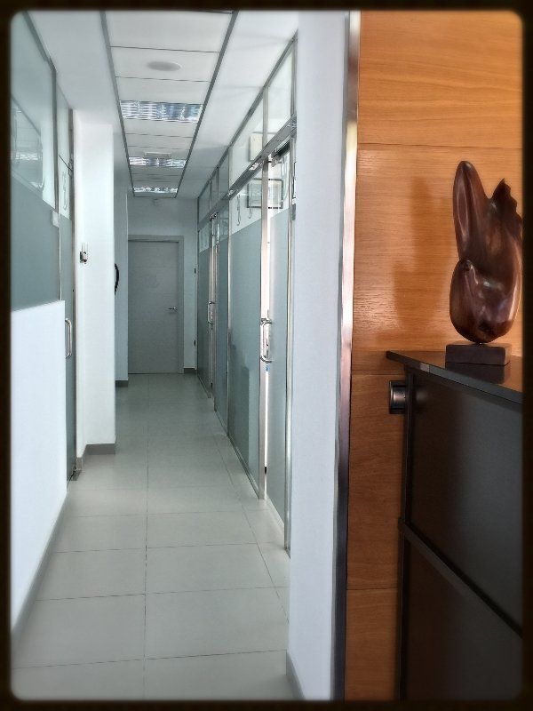 Un largo pasillo con una estatua en la esquina.