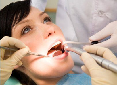 Una mujer se hace examinar los dientes por un dentista.
