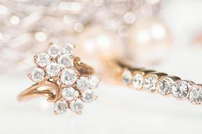 Ringcluster aus Roségold Ein Ringcluster aus Roségold und ein Ewigkeitsring mit klaren, funkelnden Steinen auf einem sanften, hellen Hintergrund.
