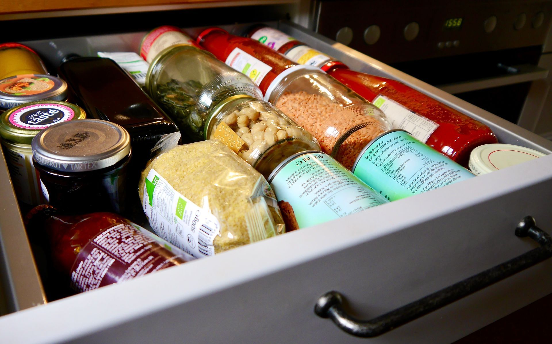 Eine Küchenschublade voller Gläser und Flaschen mit Gewürzen.