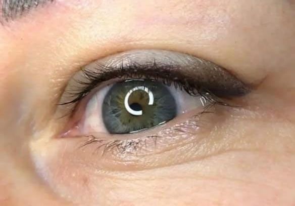 Un primer plano del ojo verde de una mujer con delineador de ojos.