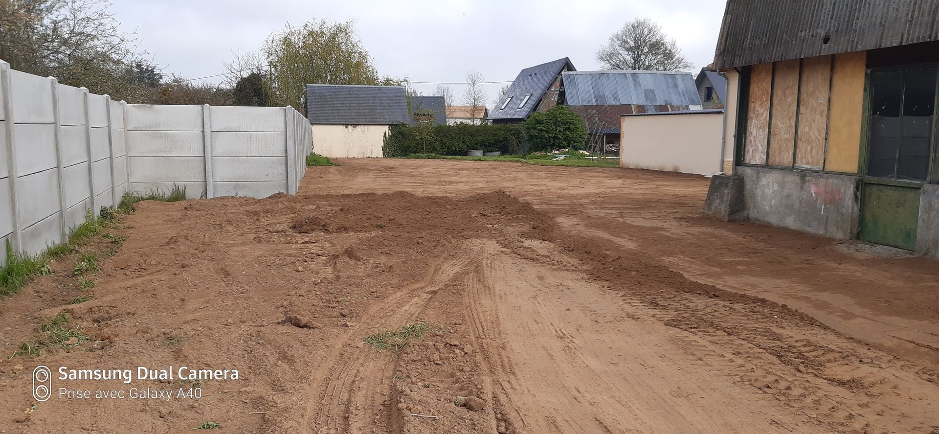 Terrain en terre avec des traces au sol d'engins de chantier