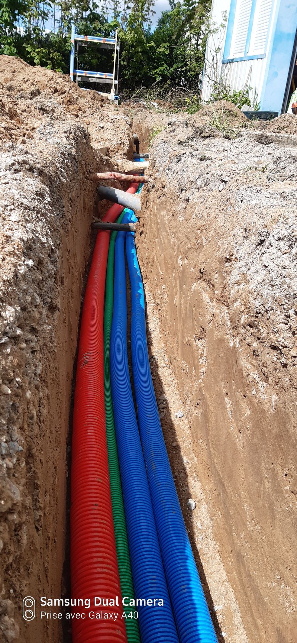 Tuyaux de gaz vert, bleu et rouge enterrés dans le sol