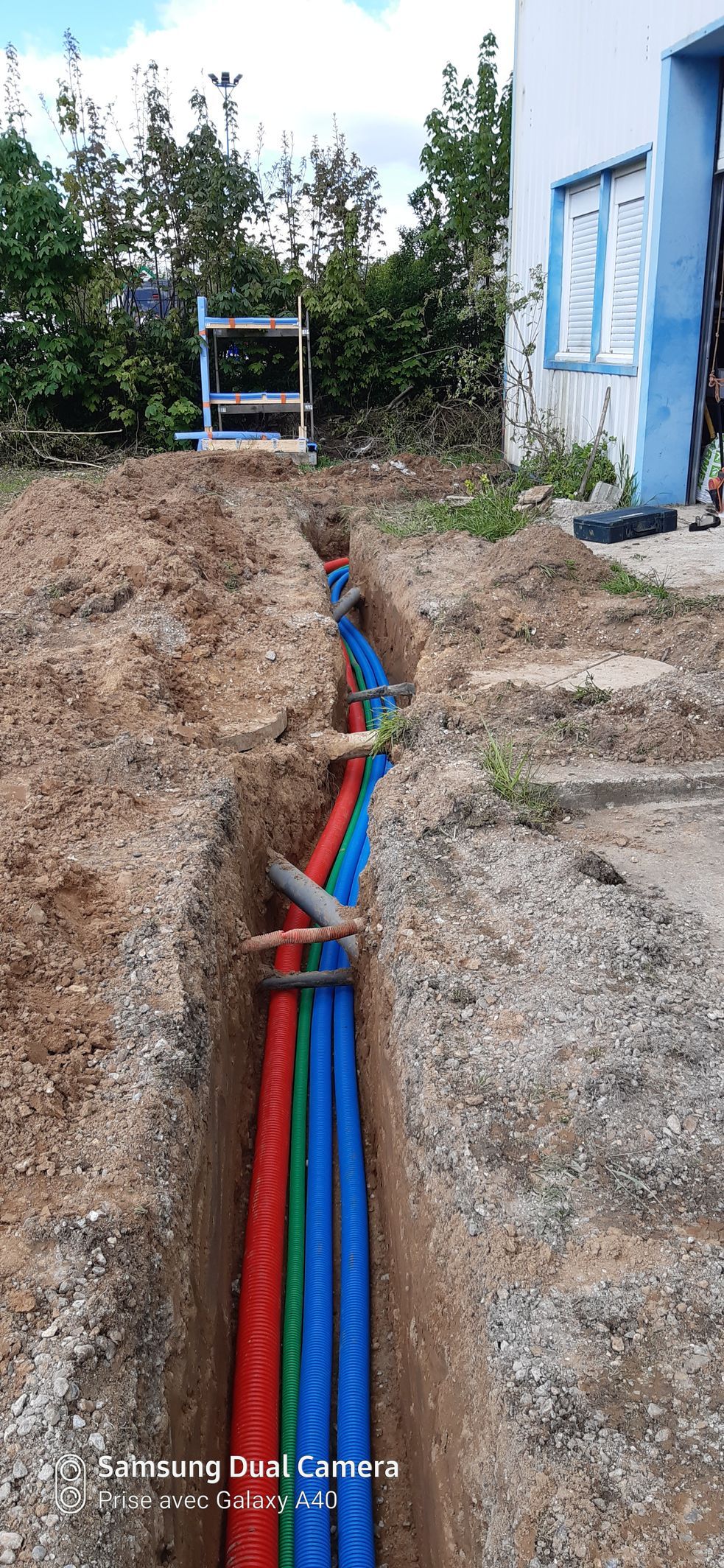 Tuyaux de gaz bleu et rouge dans une tranchée au sol