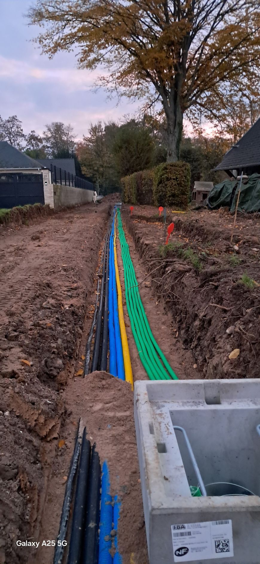 Tuyaux de téléphonie vert, jaune, bleu et noir dans le sol