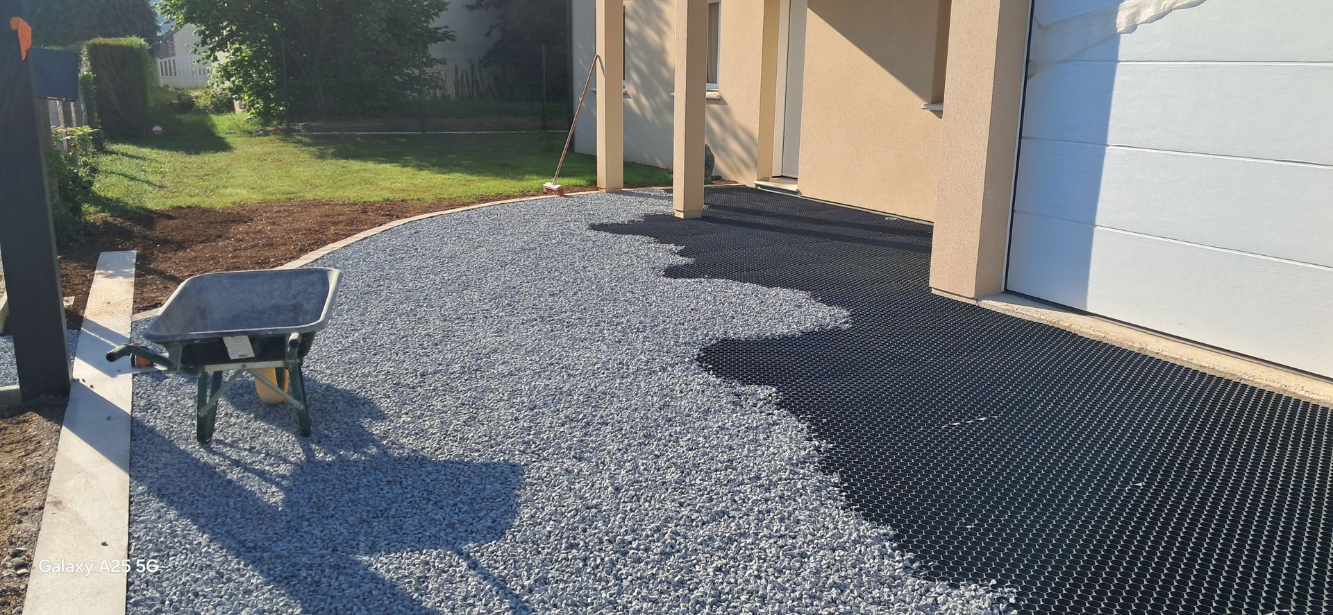 Un jardin avec allée en graviers gris clair.