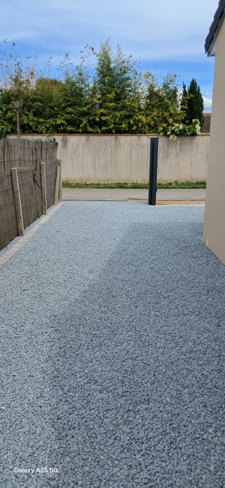 Une allée en graviers gris clair.