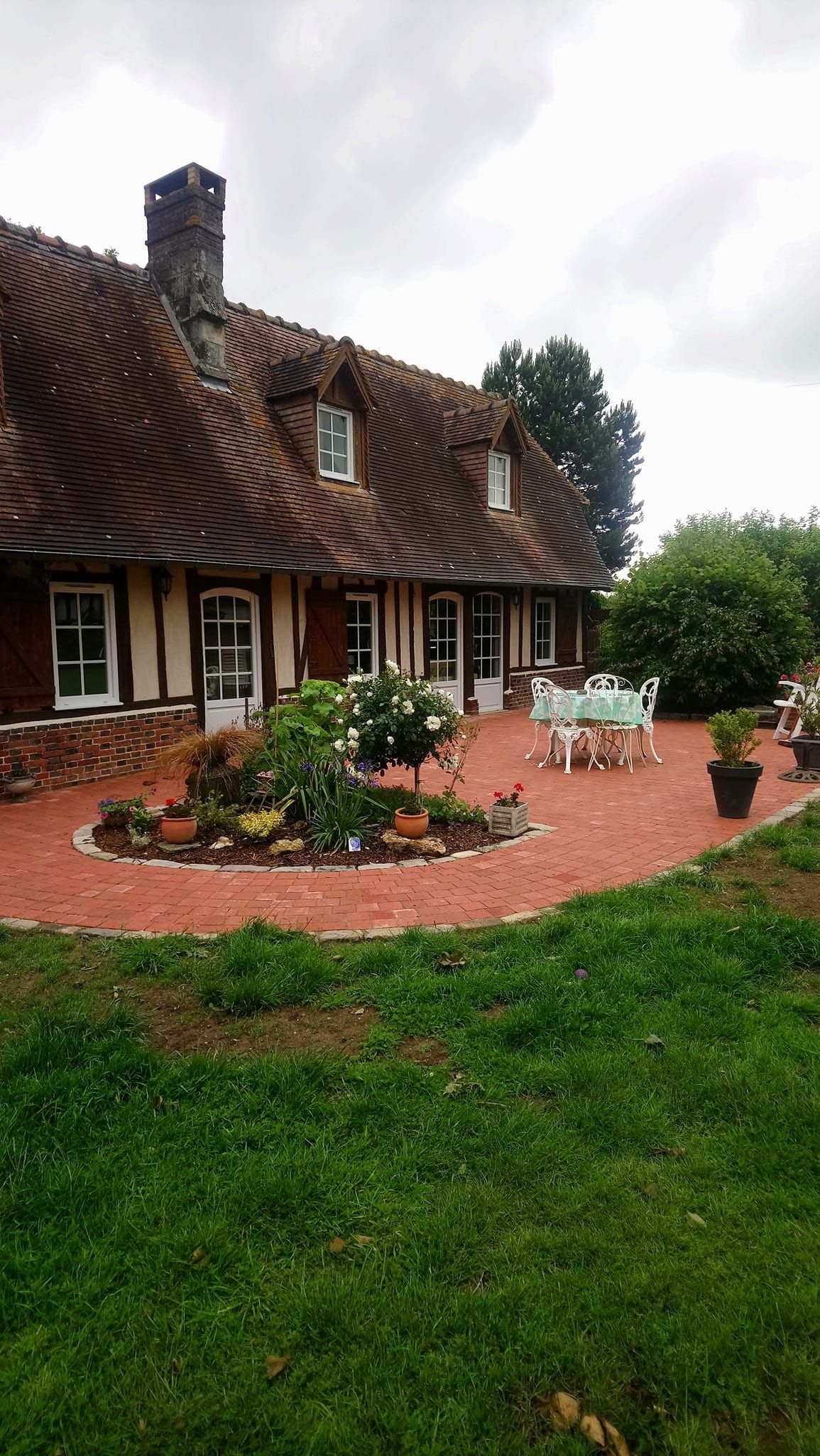 Terrasse extérieure d'une maison avec des plantes, table et chaises