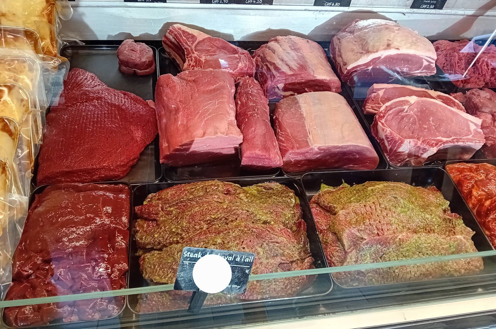 étal de boucherie avec des morceaux de viandes crues