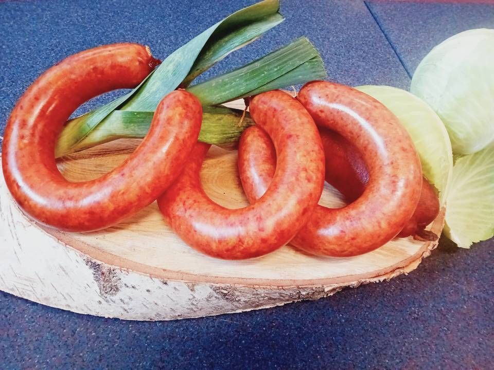 Trois saucisses sont posées sur un morceau de bois.